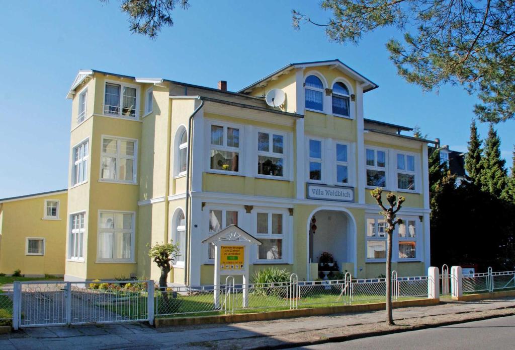 a yellow building on the side of a street at Villa Waldblick in Baabe in Baabe