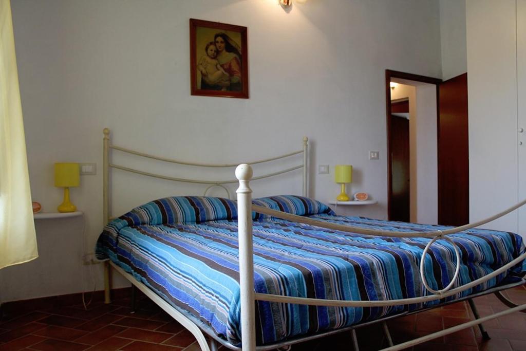 un letto con piumone blu in una camera da letto di Casa Vacanze in Borgo a Monteverdi Marittimo