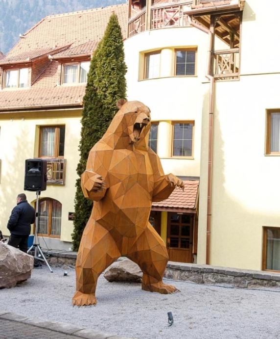a large brown bear statue in front of a building at MATT'S House in Tuşnad