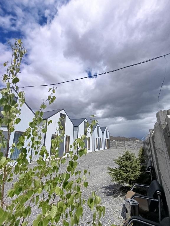 a row of white houses on top of a field at Naryn Barnhouses in Naryn