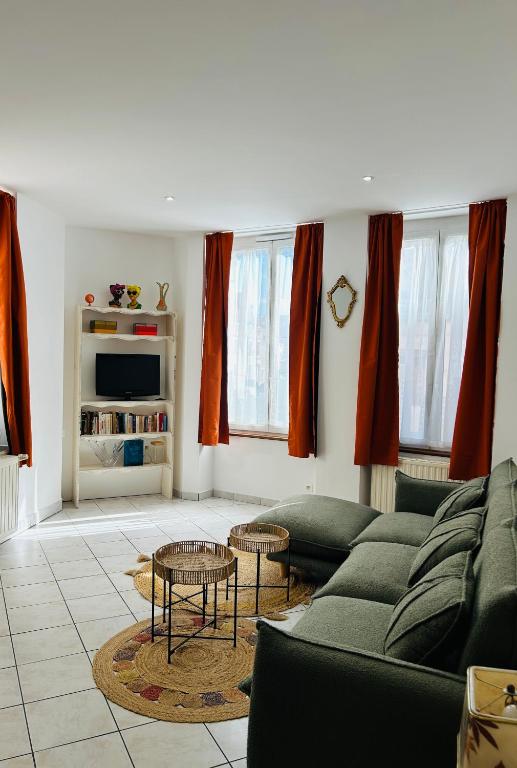 a living room with a couch and two tables at Le Néococoon in Neufchâteau