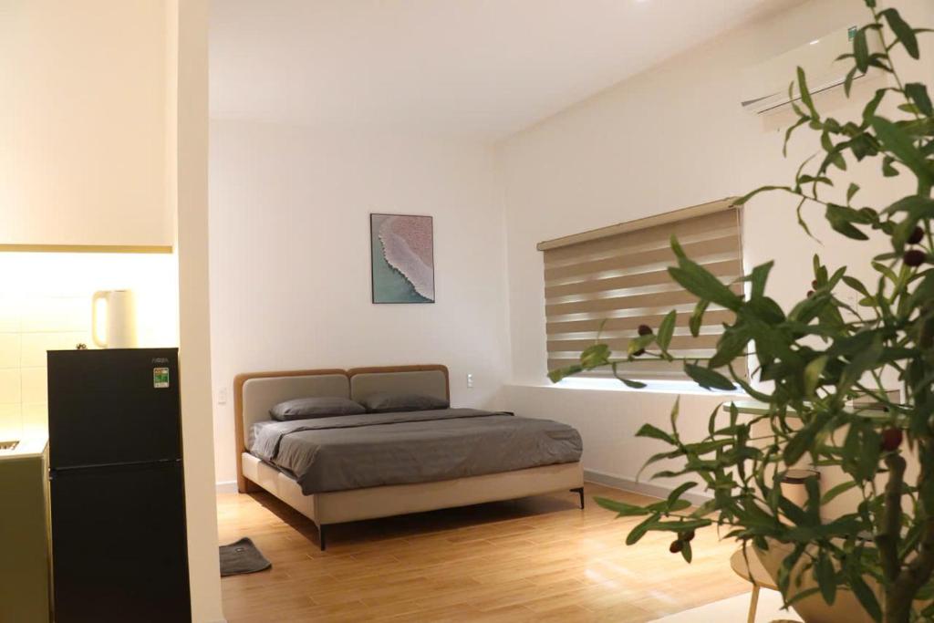 a bedroom with a bed and a potted plant at GIA Hotel & Serviced Apartment in Nhơn Trạch