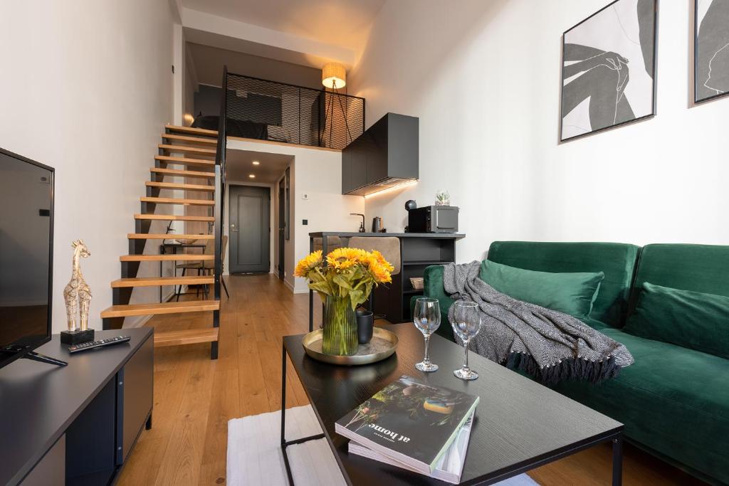 a living room with a green couch and a table at Old Town Loft in Tartu