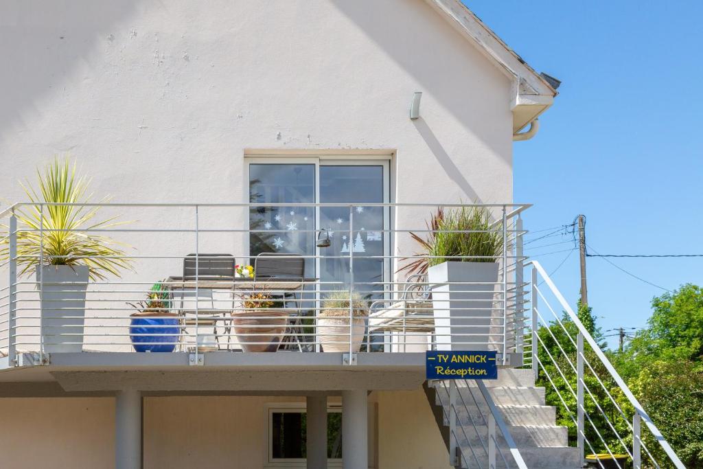 a balcony of a house with potted plants at Ty Annick chambres d'hôtes in Névez