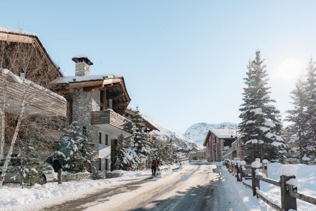 a snow covered street in a village with a building at Chalet Face - LES CHALETS COVAREL in Val-d'Isère