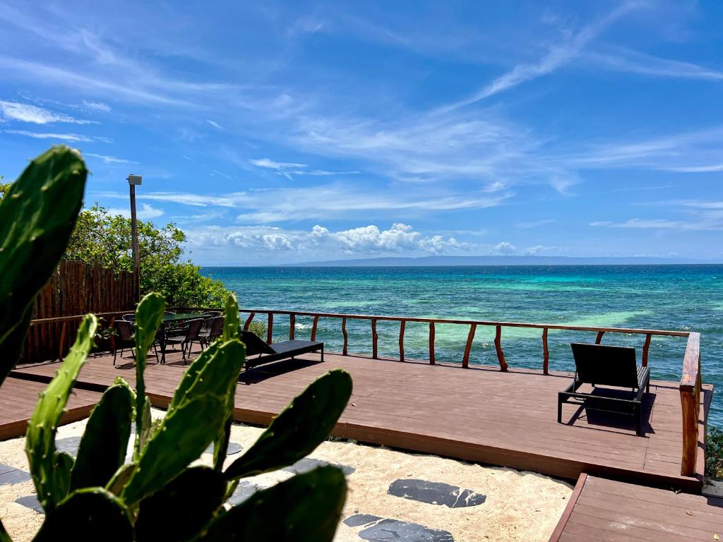 a deck with chairs and a view of the ocean at Crossa Inn in Siquijor