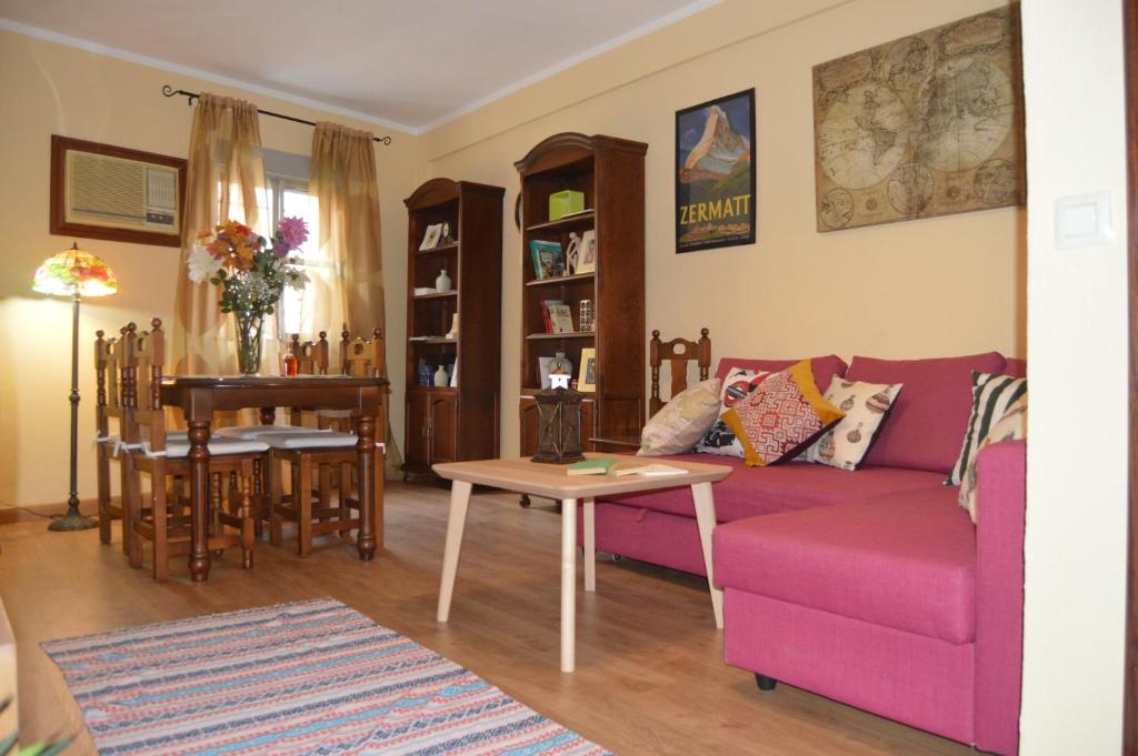 a living room with a pink couch and a table at Romantic apartment with free parking in Seville