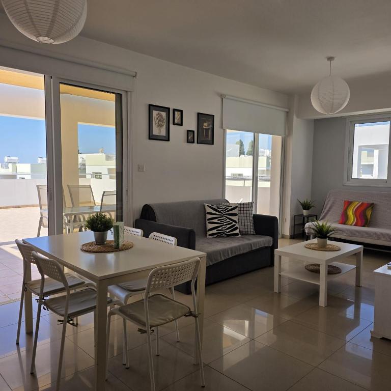 a living room with a couch and a table and chairs at Obv 2-303 in Pyla