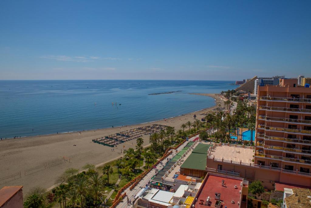 a view of a beach with a hotel and the ocean at Apartamento Tamarindos II in Benalmádena