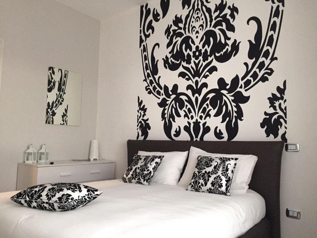 1 dormitorio con una pared estampada en blanco y negro sobre una cama en LM House, en Lonato