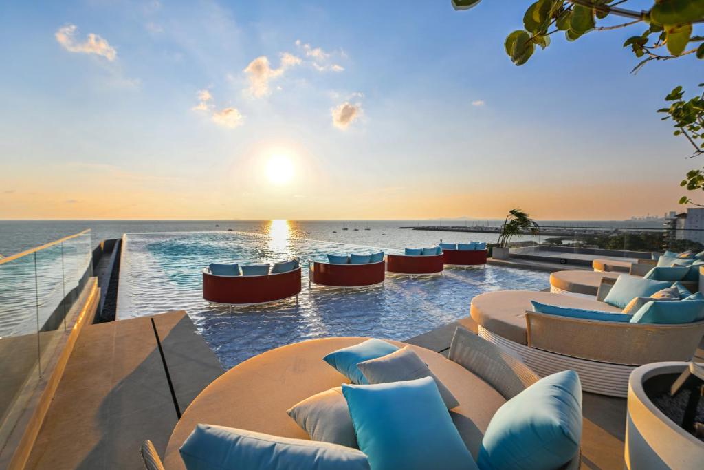 a resort with a pool with a view of the ocean at The Panora Estuaria Pattaya in Na Jomtien