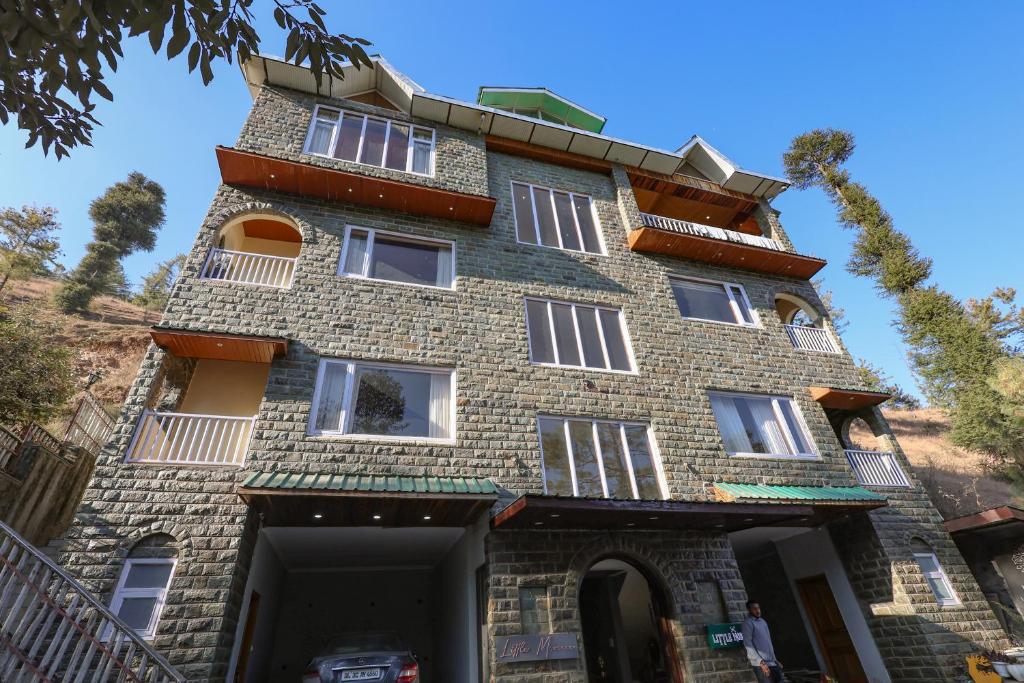 a tall brick building with white windows on it at Dancing Deer Chalet in Kūfrī