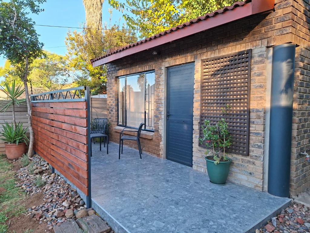 a patio in a brick house with a black door at De Windmolen in Centurion