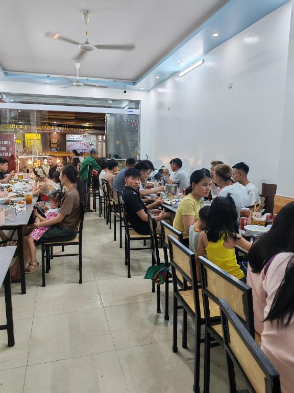 a group of people sitting at tables in a restaurant at Tùng Linh Hotel in Sầm Sơn