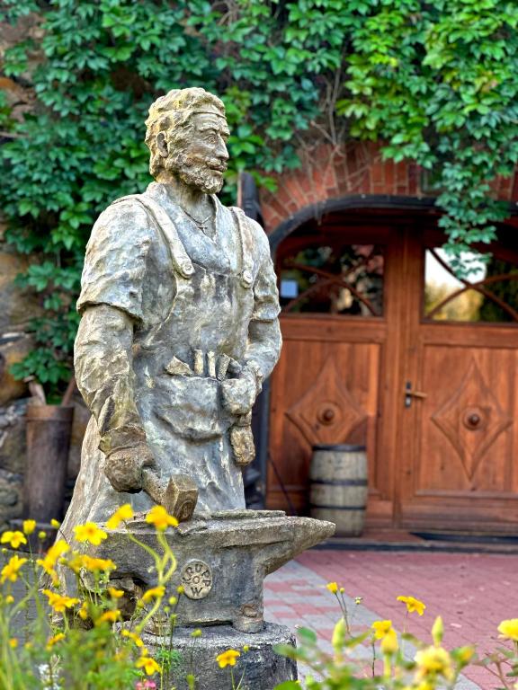 a statue of a man sitting on a fountain at At the old blacksmith in Daugavpils