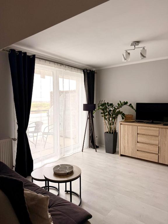 a living room with a couch and a table at Apartament Perełka in Darłowo