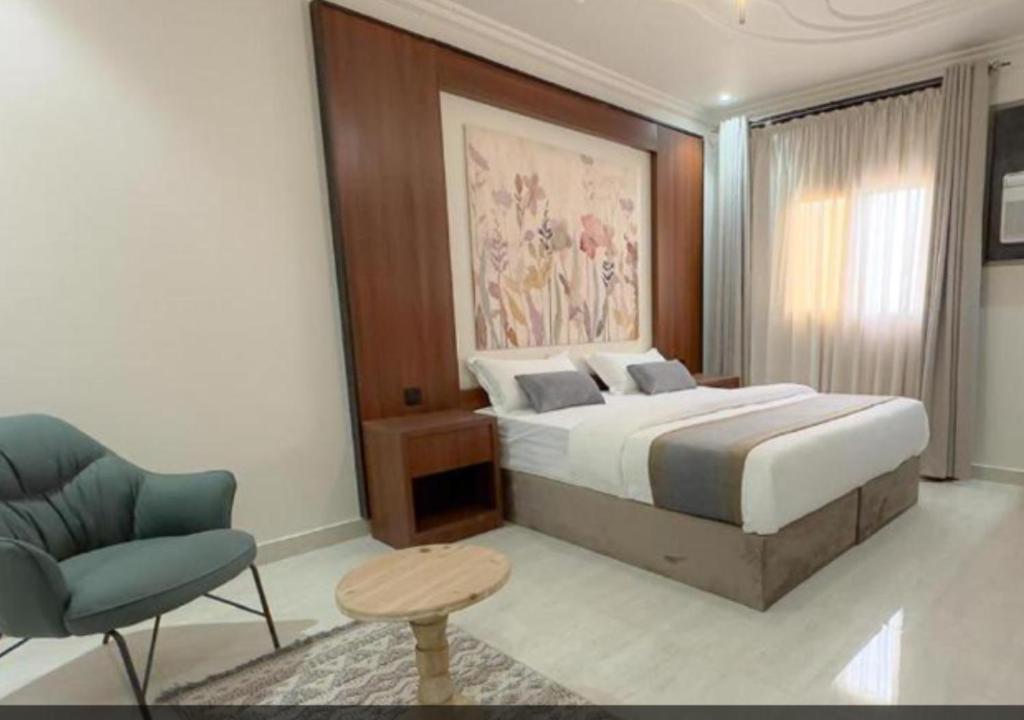 a bedroom with a bed and a chair in a room at شقق سكنية بالخالدية in Al ‘Awālī