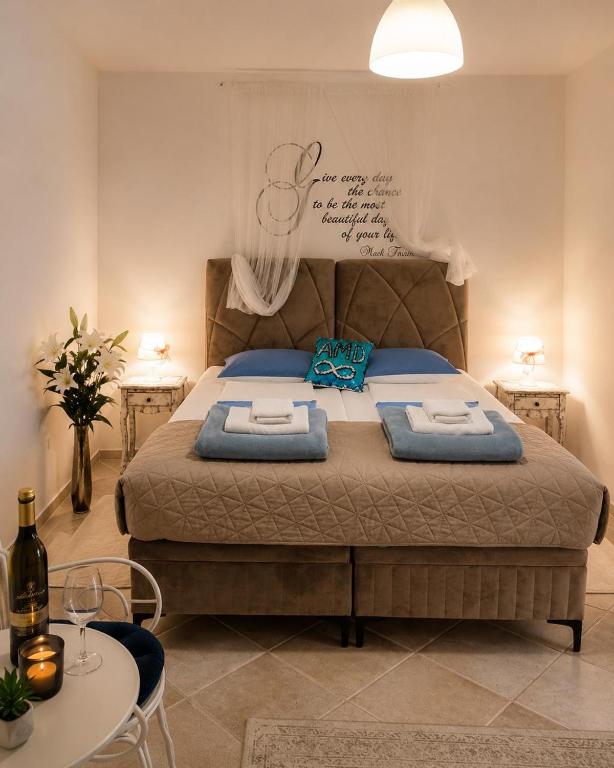 a bedroom with a large bed with two towels on it at AMD Infinity Suites in Split