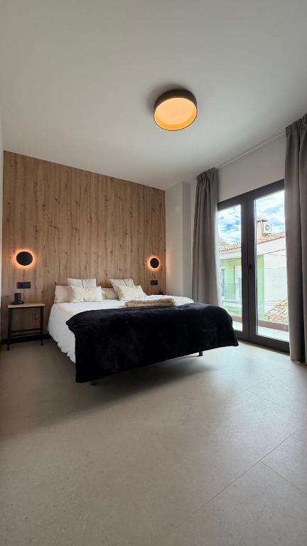 a bedroom with a large bed and a large window at HS Olivos in Alcalá del Júcar