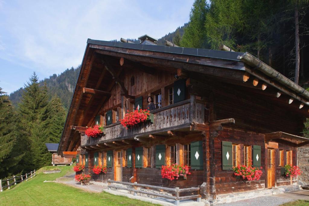 ein großes Holzhaus mit Blumen davor in der Unterkunft Le Chalet de Lara in Val dʼIlliez