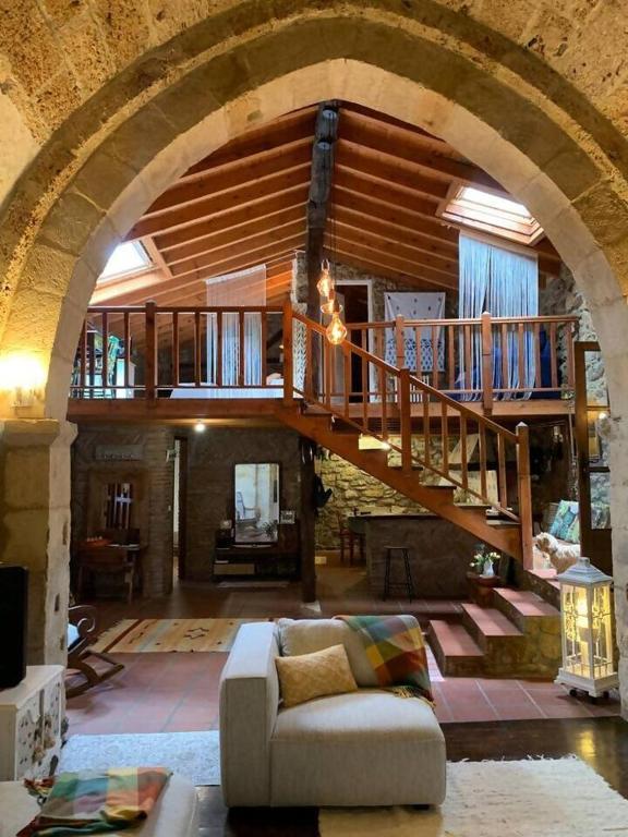 a living room with a spiral staircase in a house at Ermita de la Tuda-Villaescusa de las Torres in Villaescusa de las Torres