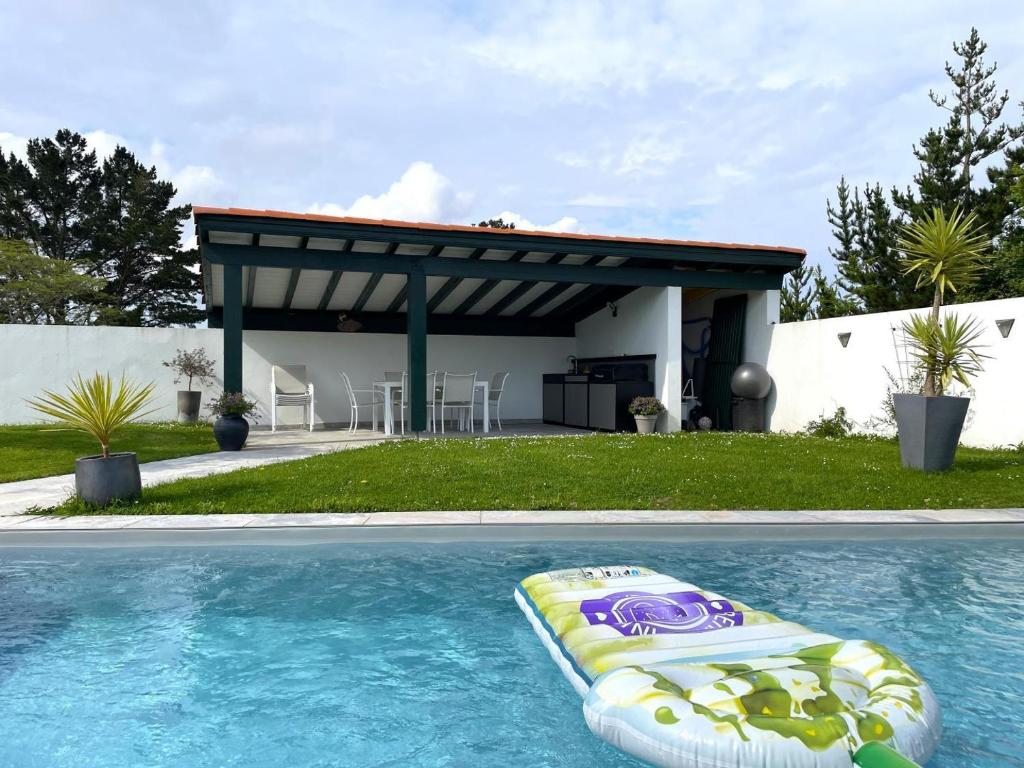 a swimming pool with a gazebo and a raft in a backyard at Uhalden borda in Saint-Jean-de-Luz