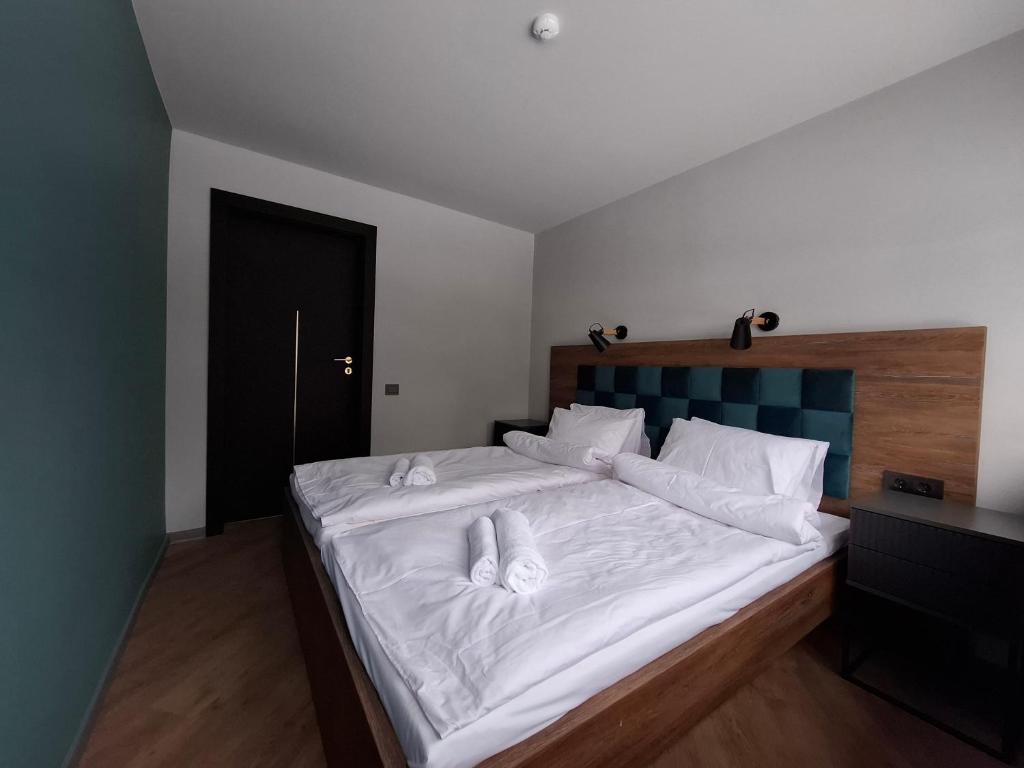 a bedroom with a large bed with white sheets at Nemunėlio vitražai in Nemunėlio Radviliškis