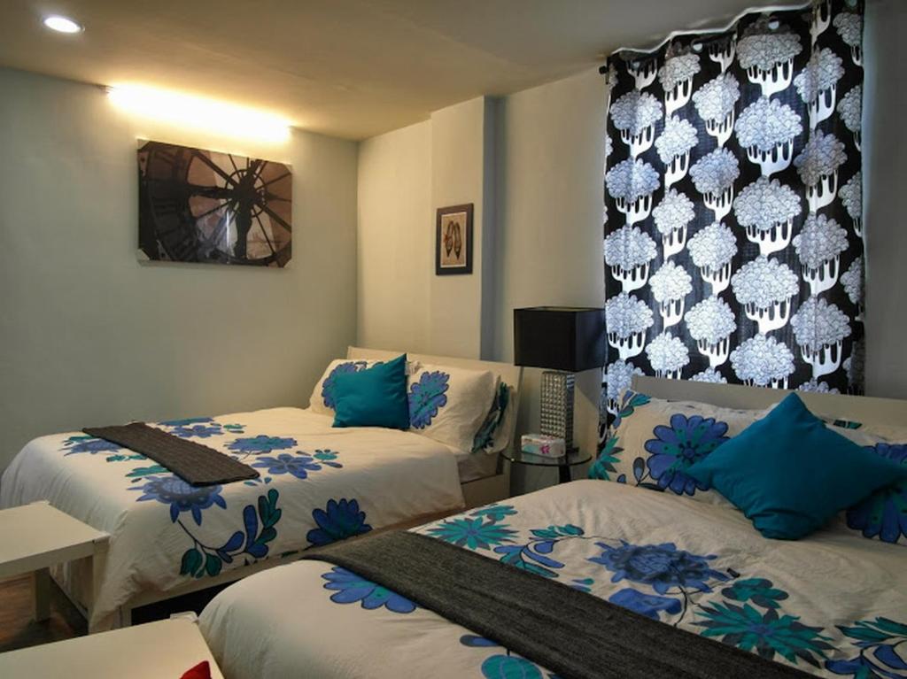 a room with two beds with blue and white sheets at Jia Mei Fa Homestay in Taitung City