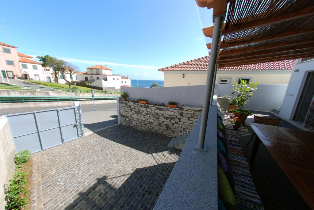 a balcony of a house with a view of the ocean at Estrela do Mar - Alojamento Local in Calheta