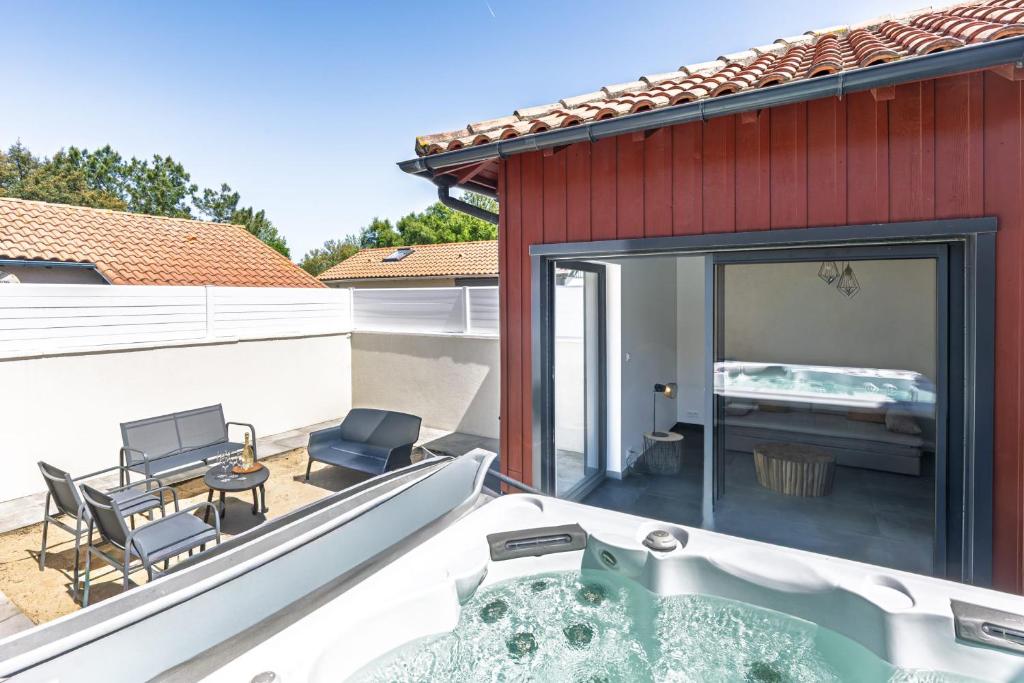 a hot tub on the balcony of a house at Cozy Cottage with Spa - Welkeys in Moliets-et-Maa