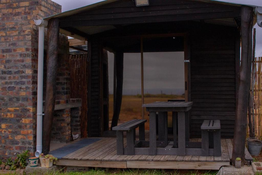 a wooden porch with benches on a brick building at Nama-Qua Game Reserve in Vredendal