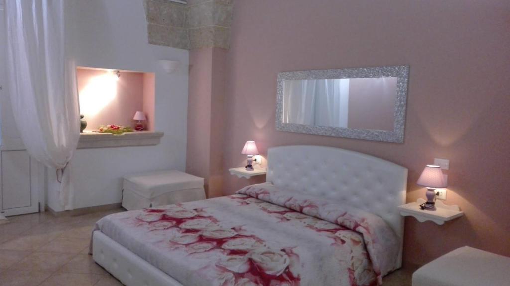 a bedroom with a bed and two tables and two lamps at Antico Casale B&B in Veglie