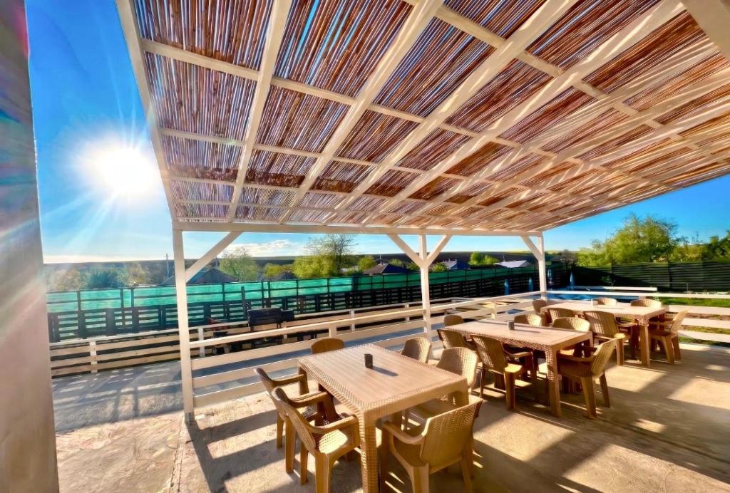 a patio with tables and chairs under a wooden ceiling at Cabana Ursu in Iaşi