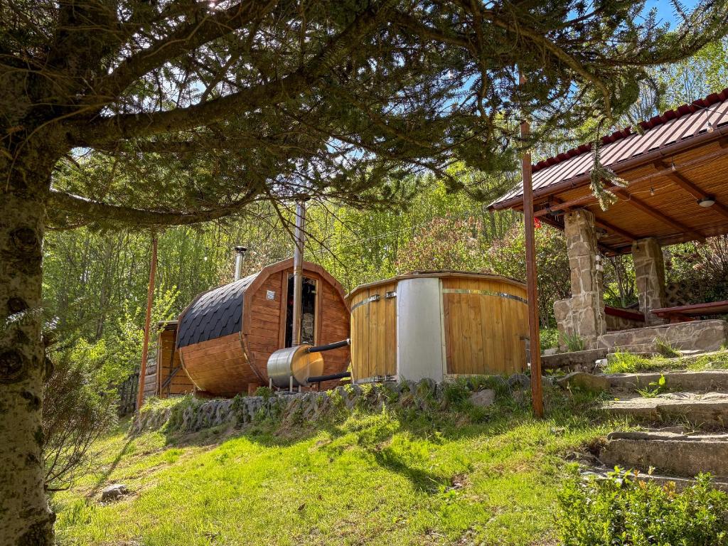 a wooden hobbit house sitting next to a house at Willa Wielka Puszcza in Porąbka