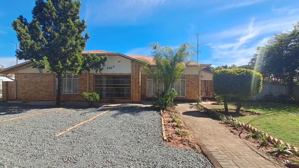 a brick house with a driveway in front of it at Rams Blissful Guest House in Rustenburg