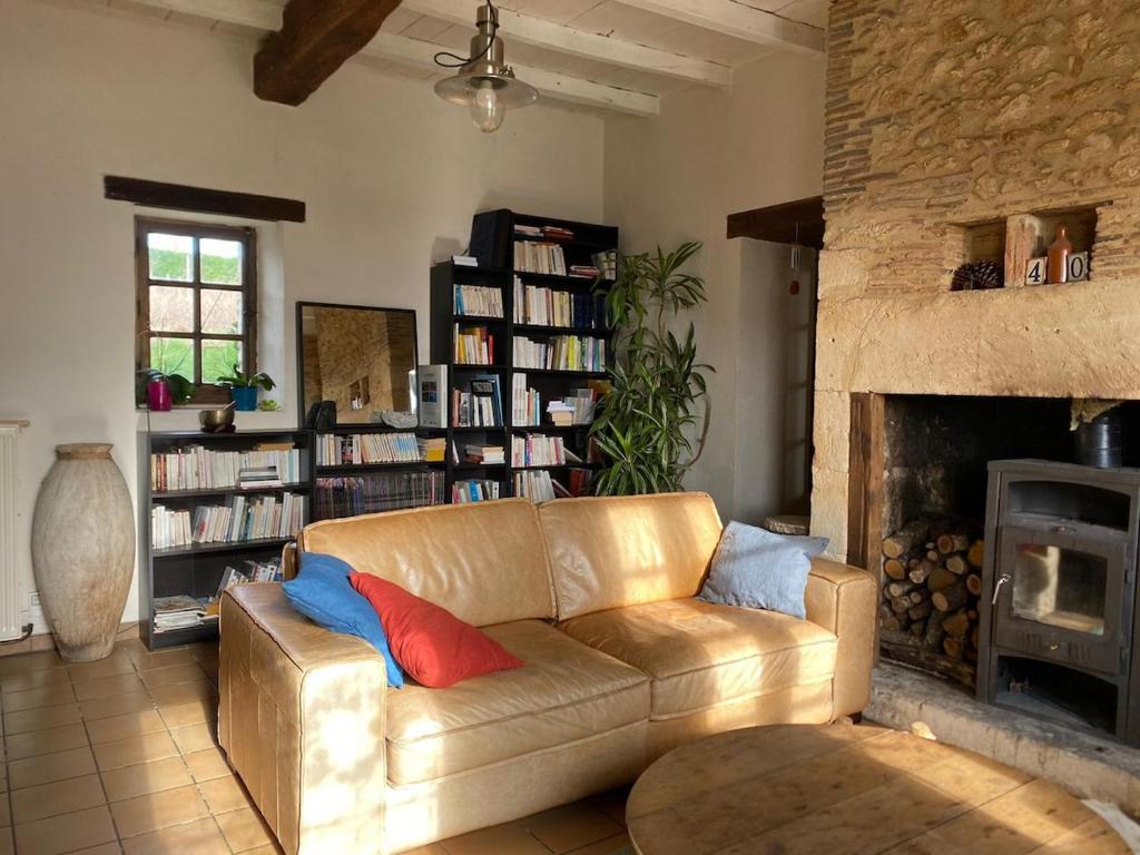 a living room with a couch and a fireplace at Maison Périgourdine familiale in Saint-Jean-dʼEyraud
