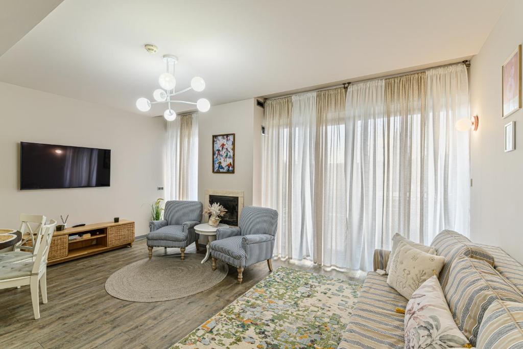 a living room with a couch and chairs and a tv at Woodland Apartment in Silver Mountain Resort in Poiana Brasov
