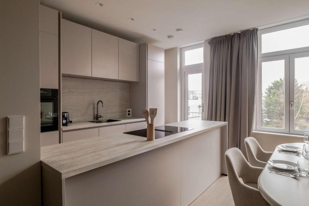 a kitchen with white cabinets and a large window at Spacious family home in Schiedam