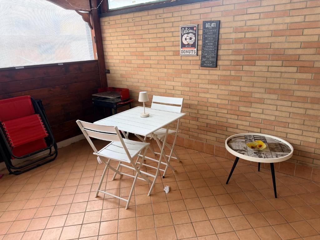 a table and chairs in a room with a brick wall at House raffy in San Severo