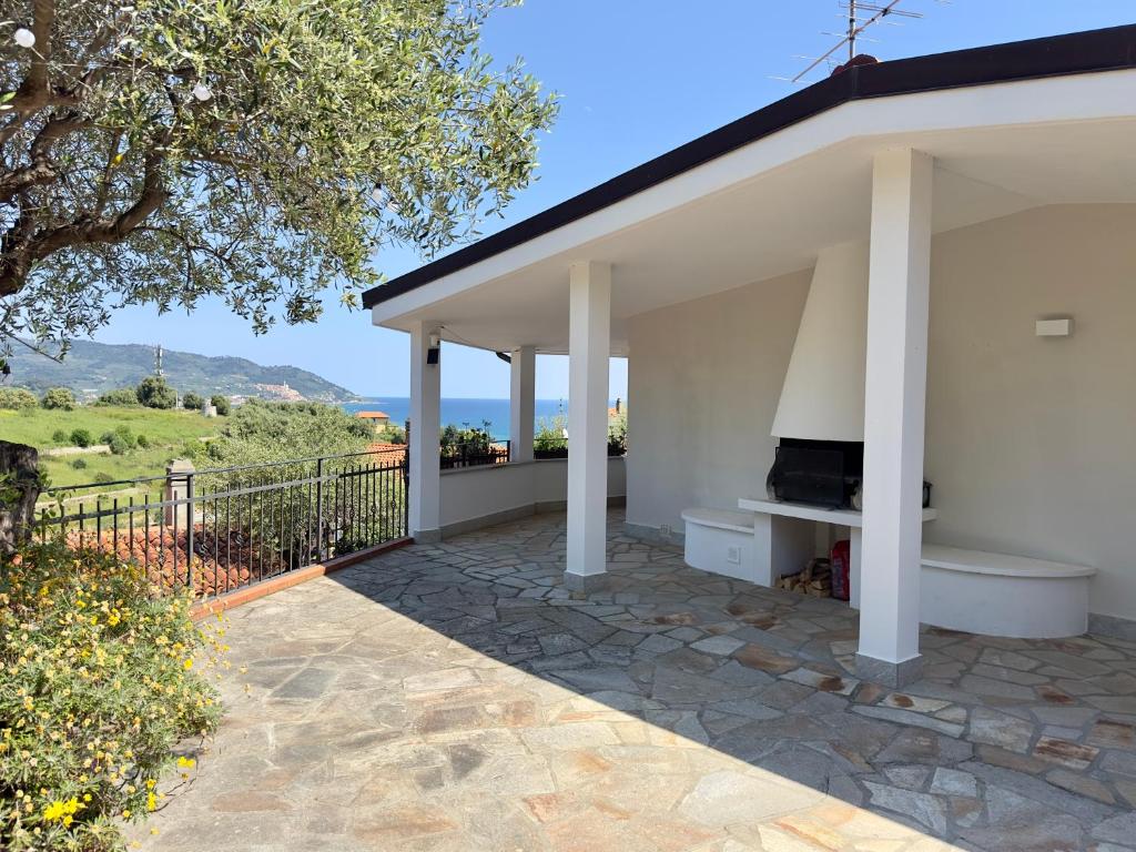 a white house with a patio with a fireplace at Villa Thalea in Diano Marina