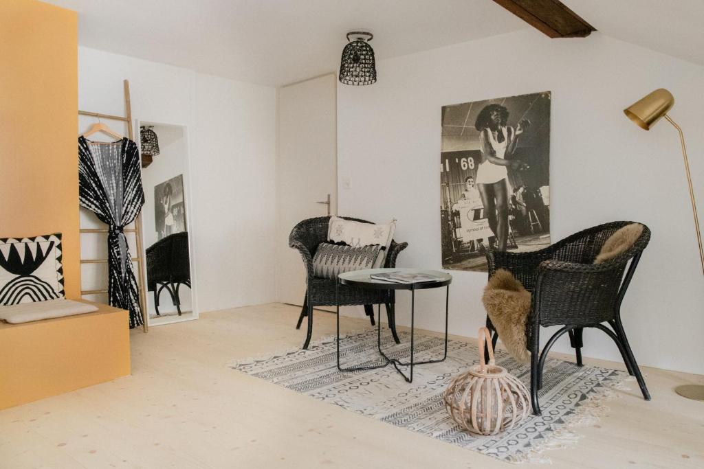 a room with chairs and a table and a painting at Flusshaus BnB Okavango in Brugg
