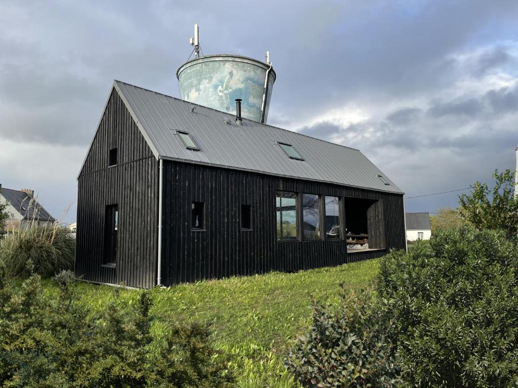 a black house with a water tower on top of it at Wooden architect-designed house in Camaret-sur-Mer