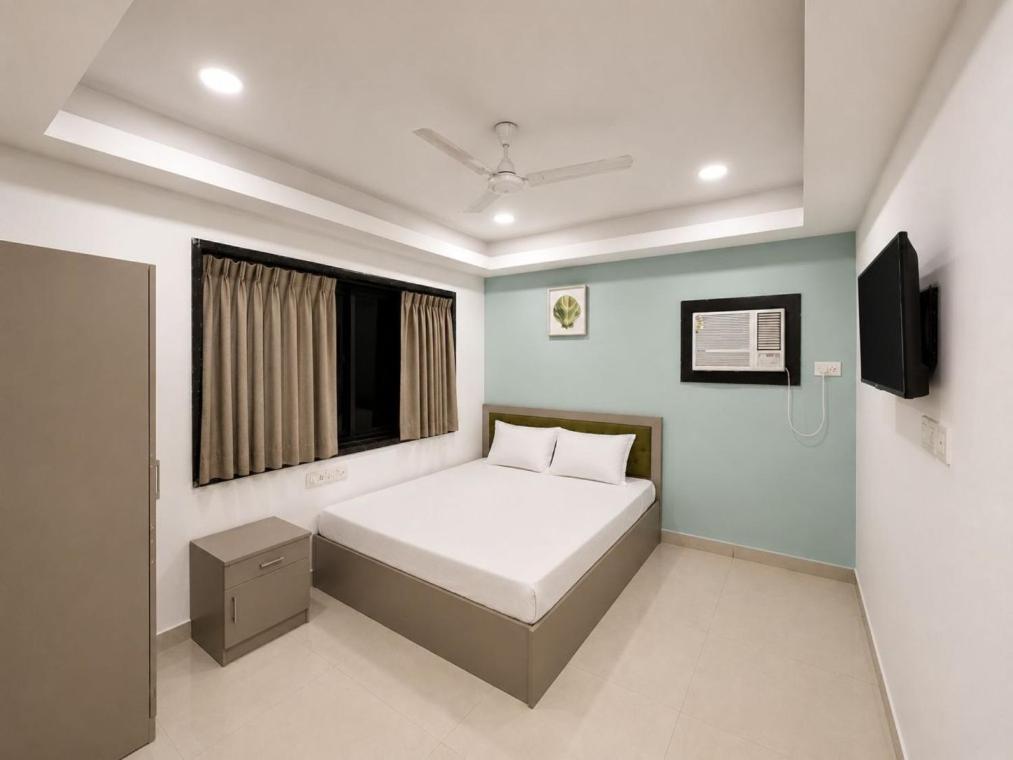 a bedroom with a white bed and a window at Hotel Sunview in Kolkata