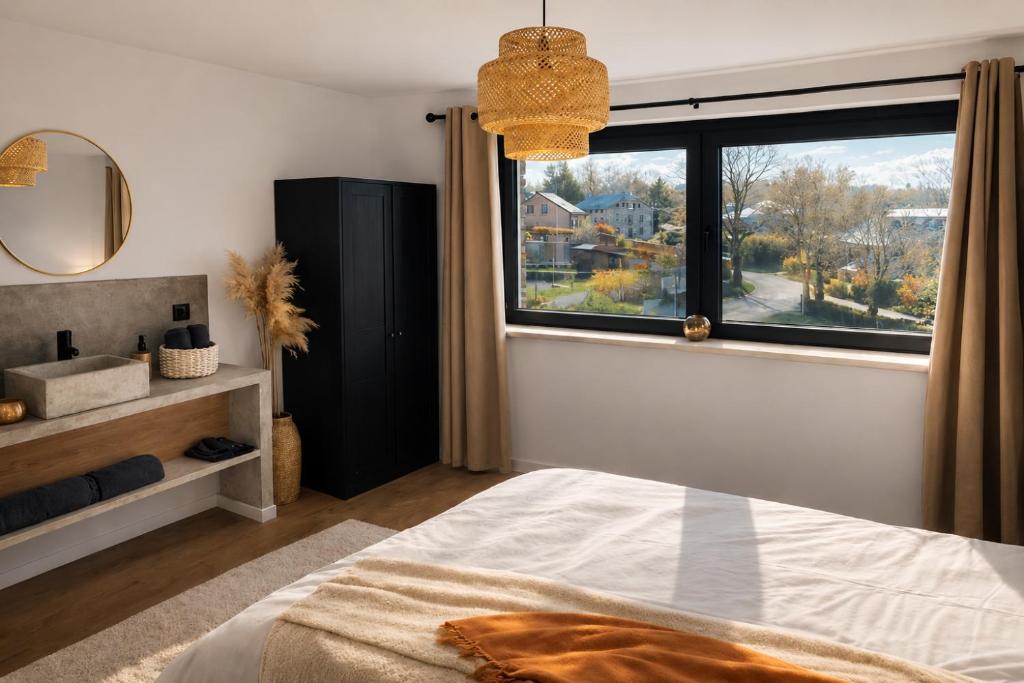 a bedroom with a bed and a large window at La maison d'à côté - Sart in Jalhay