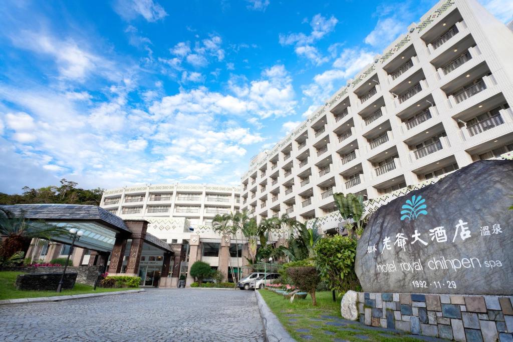 a large building with a sign in front of it at Hotel Royal Chihpin in Wenquan