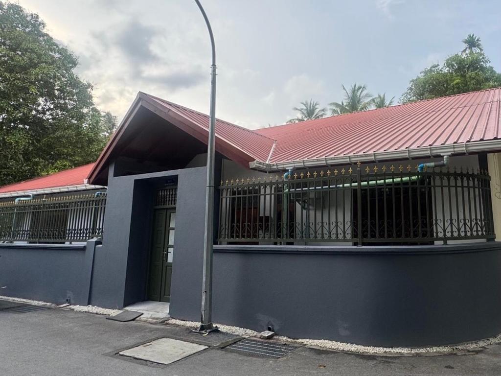 ein Gebäude mit rotem Dach und einer Straßenlaterne in der Unterkunft Beevaa Inn in Fuvahmulah