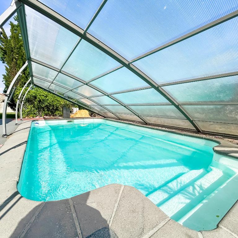 an overhead swimming pool with a glass roof at Élégante maison familiale, terrasse & piscine in Aigrefeuille-sur-Maine