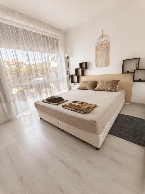 a bedroom with a large bed and a large window at Decor in Atlantis Resort&SPA by RV Apartments in Burgas