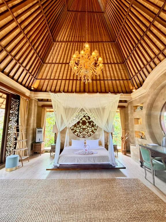 a large bedroom with a bed with a chandelier at Akasha New Earth Haven Villa in Ubud