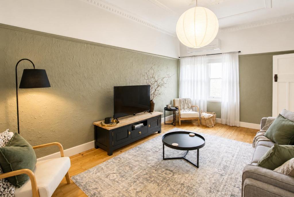 a living room with a flat screen tv on a wall at Central 3BR Heritage Home Walk to Sovereign Hill & CBD Free Parking in Ballarat